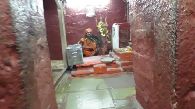 Inside Bhartrihari Gufa, Ujjain: a Nath sadhu seated in one of the red-painted stone chambers (2018)